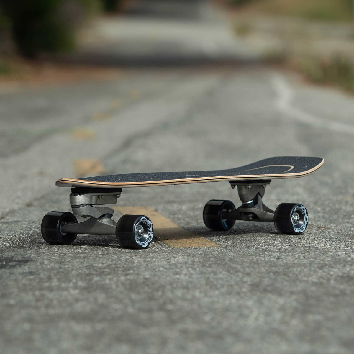 Planche Carver Resin sur la route, arrière-plan flou